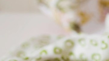 cheesecake de limón decorado con limones sobre una mesa de madera con un fondo blanco