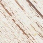 Plato blanco con una cheesecake de yogur griego cortada por pedazos sobre una mesa de madera