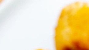 Plato blanco con muchas croquetas de queso azul en forma de bolas