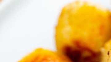 Plato blanco con muchas croquetas de queso azul en forma de bolas