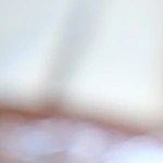 Plato blanco hondo con enmoladas de mole negro decoradas con una ensalada de aguacate