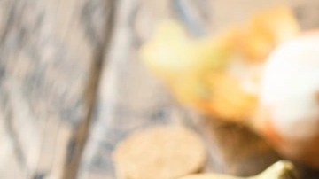 Quiche de cebolla caramelizada, pera y romero de forma redonda sobre una tabla de madera