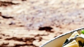 Sartén con rigatoni con ricotta y espinacas sobre una mesa de madera