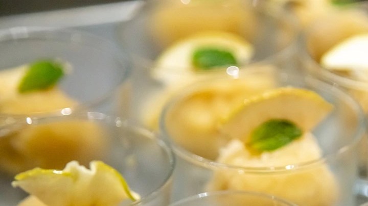 Vasos de vidrio con bolas de sorbete de manzana verde, decorado con menta