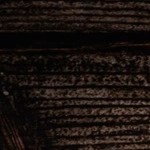 Un pedazo de tarta de queso gallega completa sobre una mesa de madera