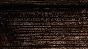 Un pedazo de tarta de queso gallega completa sobre una mesa de madera