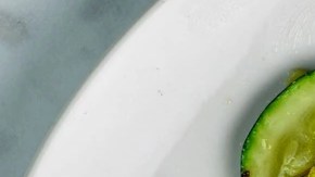 Plato blanco sobre una mesa de madera con vegetales salteados