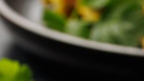 Waffle de calabacín y queso sobre un plato negro decorado con crema y perejil