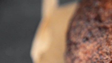 Rodajas de pan de semilla sobre papel kraft en una mesa gris