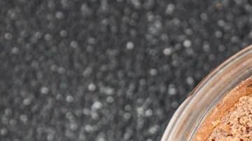 Recipiente transparente con paté de vermut sobre una mesa gris