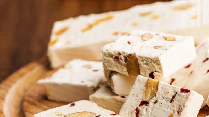 Pedazos de turrón de avellanas sobre una tabla de madera