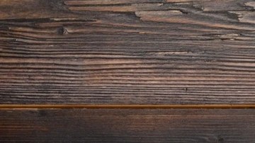 Plato blanco con pedazos de turrón de pistachos sobre una mesa de madera