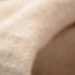 Una taza gris con adobo de chile verde sobre una mesa decorada con chiles verdes