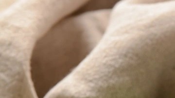 Una taza gris con adobo de chile verde sobre una mesa decorada con chiles verdes