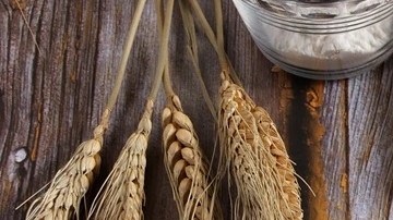 Un pedazo de crepa de pizza sobre un plato blanco en una mesa de madera
