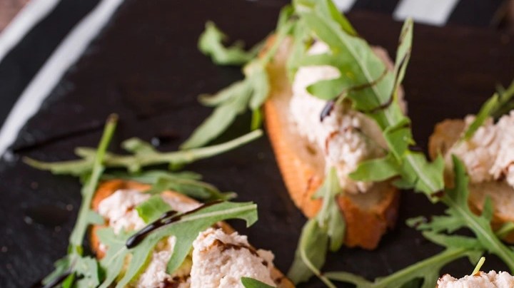 Rodajas de pan con paté al vino blanco decorado con perejil