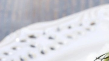 Plato decorado con perejil con unos rollos de pollo con jamón serrano, espinacas y queso