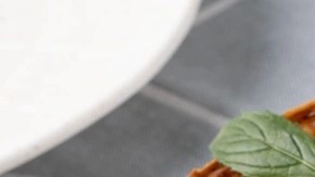 Pedazos de tarta de queso de panela sobre un plato blanco, decorado con menta