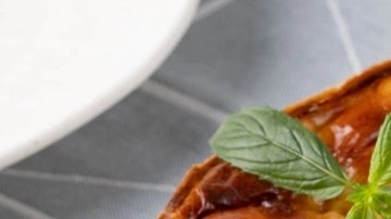 Pedazos de tarta de queso de panela sobre un plato blanco, decorado con menta