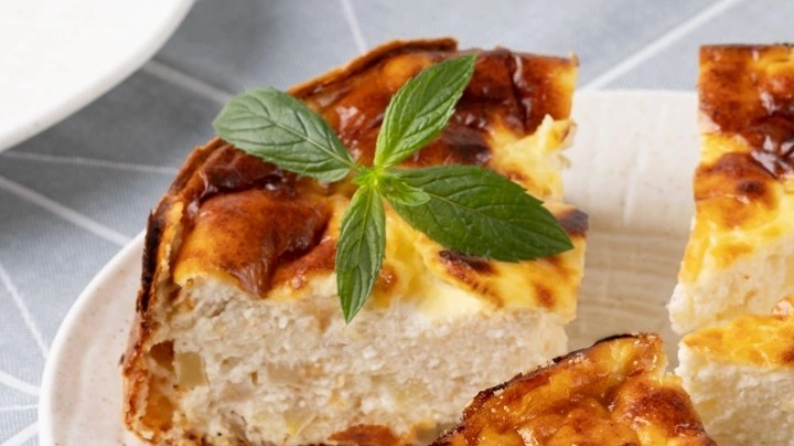 Pedazos de tarta de queso de panela sobre un plato blanco, decorado con menta