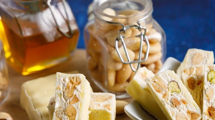 Envases de vidrio con pedazos de turrón de nata y nueces