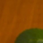 Frasco de vidrio con compota de mango, sobre una mesa de madera, decorada con cucharas y mangos