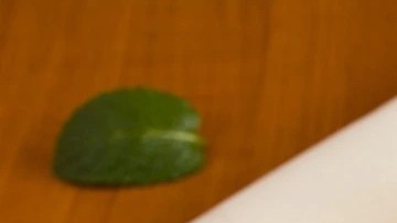 Frasco de vidrio con compota de mango, sobre una mesa de madera, decorada con cucharas y mangos