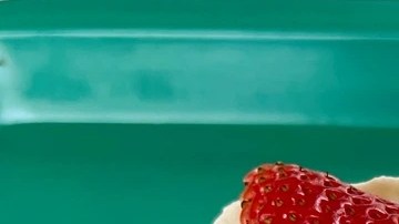 Plato blanco con merengón colombiano, decorado con fresas y melocotones