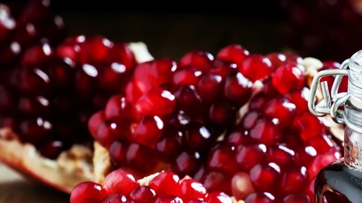 Tarro de vidrio con mermelada de granada decorado con frutas de granada