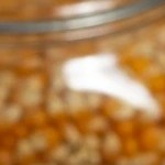 Recipiente blanco hondo sobre una mesa de madera con palomitas con chocolate