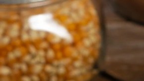 Recipiente blanco hondo sobre una mesa de madera con palomitas con chocolate