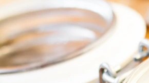 Recipiente de vidrio con paté de faisán sobre mesa de madera decorado con hierbas