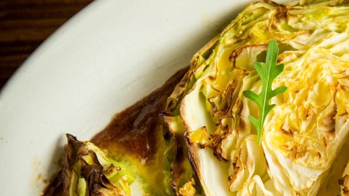 Pedazos de repollo al horno sobre una bandeja blanca