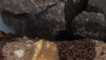 Pedazos de turrón de trufa, sobre una mesa de madera con frutos secos