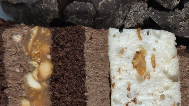 Pedazos de turrón de trufa, sobre una mesa de madera con frutos secos