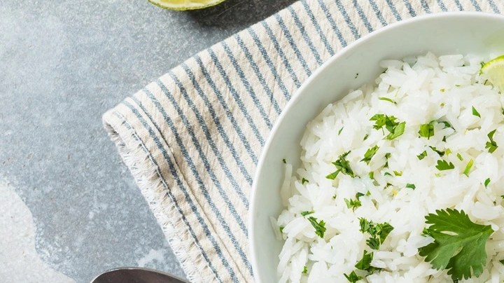 Arroz al cilantro en un plato de cerámica sobre una mesa decorada