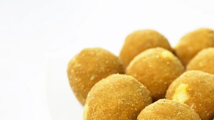 Plato blanco de ladoo frito sobre un fondo blanco