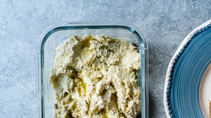 Paté de alcachofas con limón en un recipiente de vidrio junto a dos tostadas de pan