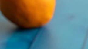 Picarones de camote con miel en un plato blanco sobre una mesa azul