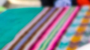 Caldo sobre una plato hondo color blanco y un mantel de colores