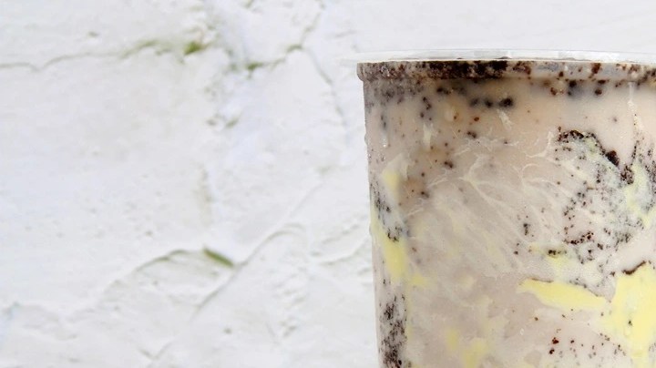 Vaso de cheesecake tea, la bebida decorada con chocolate sobre un fondo blanco