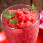 Granizado de granada en un vaso de cristal decorado con menta