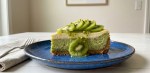 Pedazo de cheesecake de kiwi sobre un plato azul