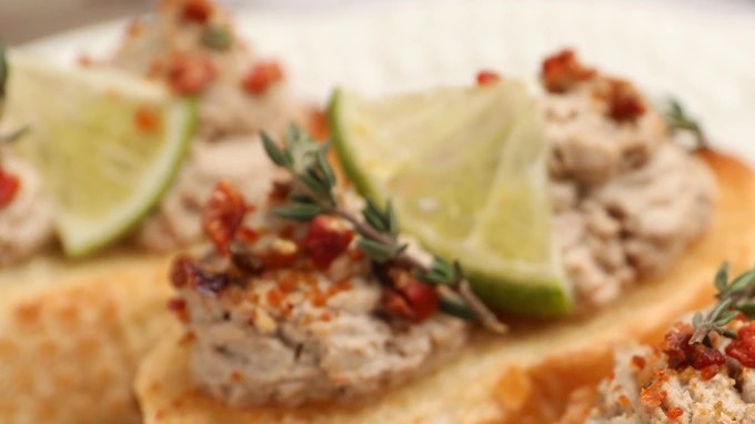 Paté de codorniz sobre un pan tostado y sobre un plato blanco