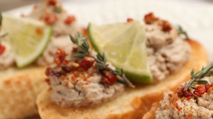 Paté de codorniz sobre un pan tostado y sobre un plato blanco