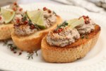 Paté de codorniz sobre un pan tostado y sobre un plato blanco