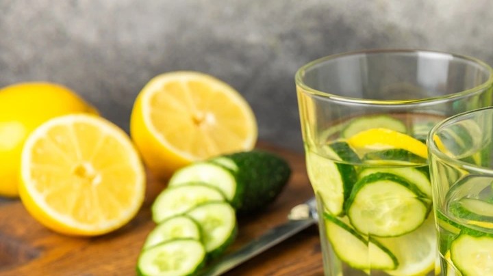 Dos vasos de vidrio con agua de pepino con limón