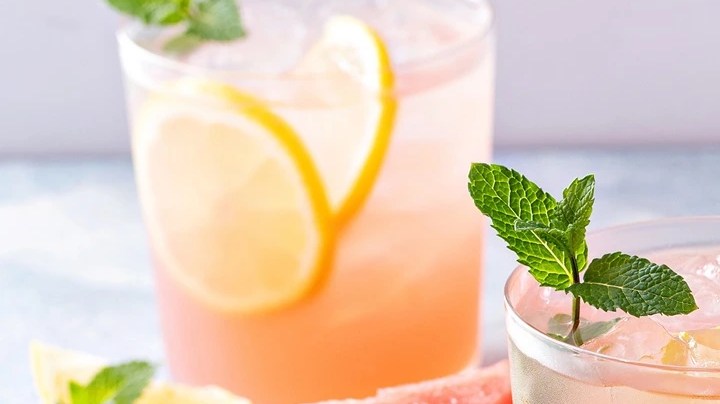 Agua fresca de sandía en vasos de vidrio decorado con sandía, limón y hojas de mentas