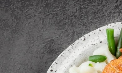 Salmón con verduras al vapor en un plato blanco