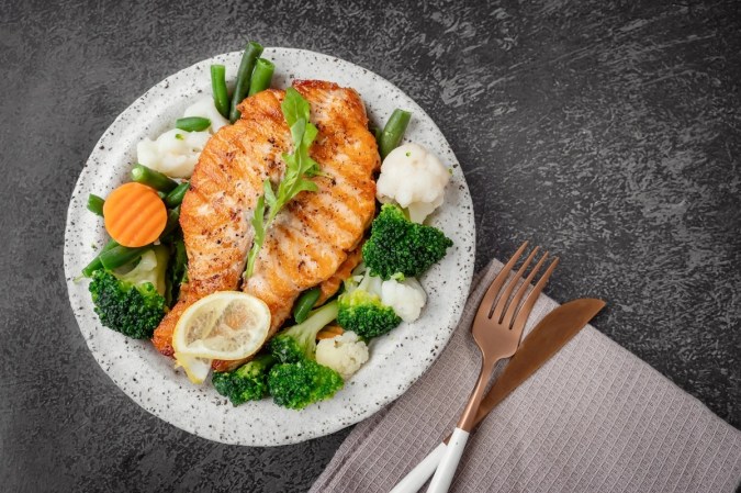 Salmón con verduras al vapor en un plato blanco